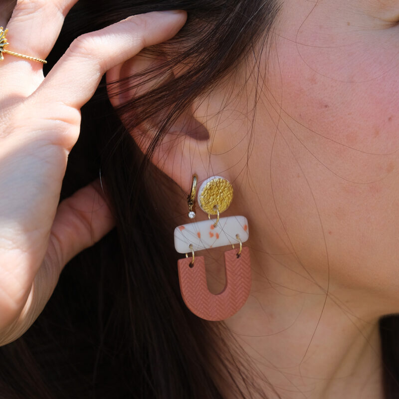 Les boucles d'oreilles fantaisies Cléo terracotta et dorée apportent une touche tendance à vos looks, tout en restant faciles à porter au quotidien.