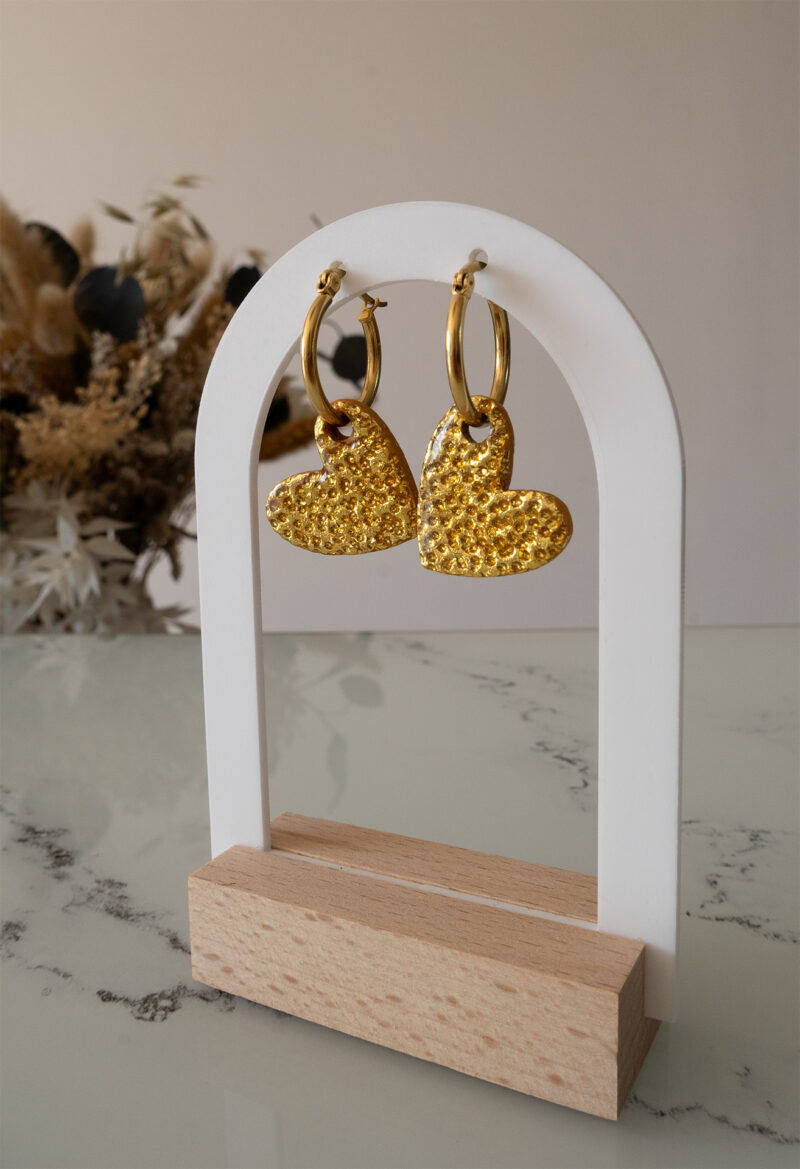 Apportez une touche d’élégance romantique à votre tenue grâce aux créoles avec cœur interchangeable, Aimée. Ces boucles d’oreilles artisanales se distinguent par un joli cœur asymétrique en feuille d'or martelé à la main, posé sur une créole dorée ou argentée à choisir selon vos préférences. Polyvalentes, ultra légères et confortables, elles sublimeront aussi bien une tenue décontractée qu’un style plus sophistiqué.
