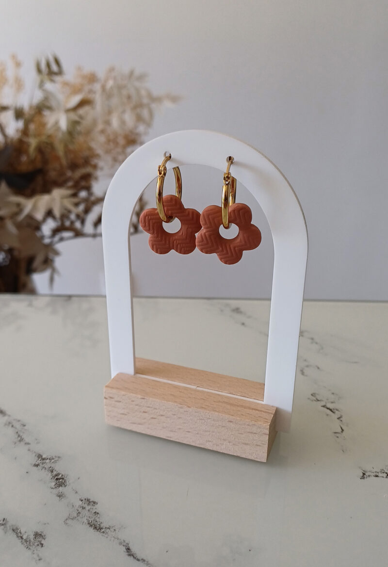 Apportez une touche poétique à vos looks avec les créoles avec fleurs interchangeables April. Ces boucles d’oreilles délicates se distinguent par une fine fleur à cinq pétales, de couleur terracotta et avec une joli texture, posée sur une créole à choisir selon vos préférences. Inspirées par la nature, polyvalentes et confortables, elles sublimeront aussi bien une tenue décontractée qu’un style plus sophistiqué. Elles sont réversibles,