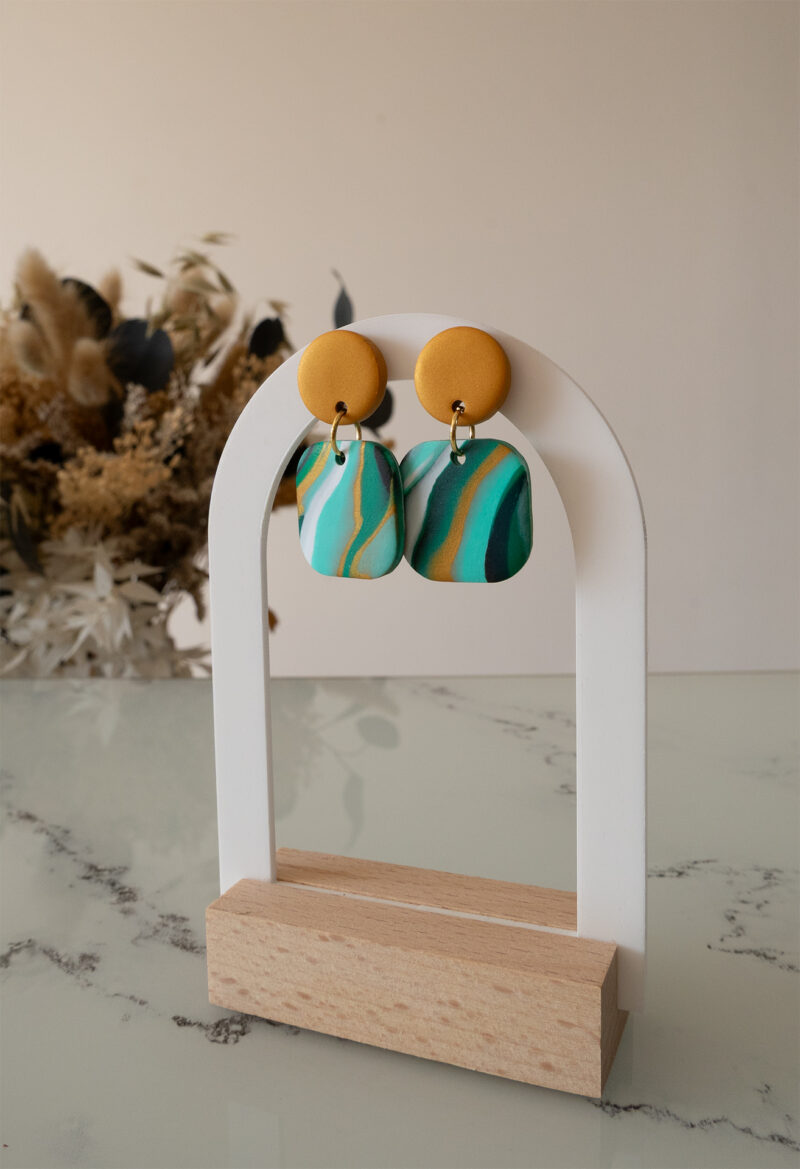 Ajoutez une touche de modernité minimaliste à votre style avec les boucles d’oreilles faites main Élodie. Ces pièces uniques associent un rond d’un beau doré nacré à un carré aux bords arrondis, marbré avec 3 couleurs de vert différents, du blanc du noir et du doré nacré. Parfaites pour toutes les occasions, elles apportent une subtilité contemporaine à vos tenues, qu’elles soient casual ou habillées.