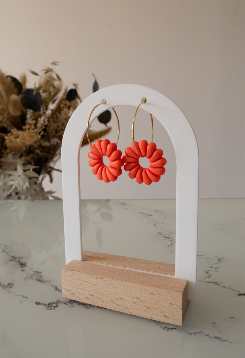 Apportez une touche de luminosité à votre tenue grâce aux créoles avec soleil interchangeable, June. Ces boucles d’oreilles délicates se distinguent par un soleil corail modernisé posé sur une créole dorée ou argentée, à choisir selon vos préférences.