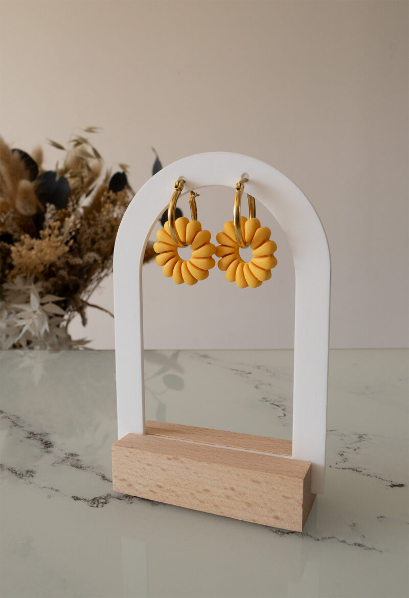 Apportez une touche de luminosité à votre tenue grâce aux créoles avec soleil interchangeable, June. Ces boucles d’oreilles délicates se distinguent par un soleil jaune modernisé posé sur une créole dorée ou argentée, à choisir selon vos préférences.