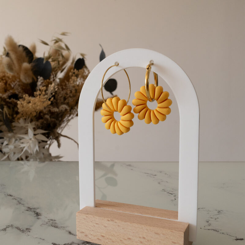 Apportez une touche de luminosité à votre tenue grâce aux créoles avec soleil interchangeable, June. Ces boucles d’oreilles délicates se distinguent par un soleil jaune modernisé posé sur une créole dorée ou argentée, à choisir selon vos préférences.