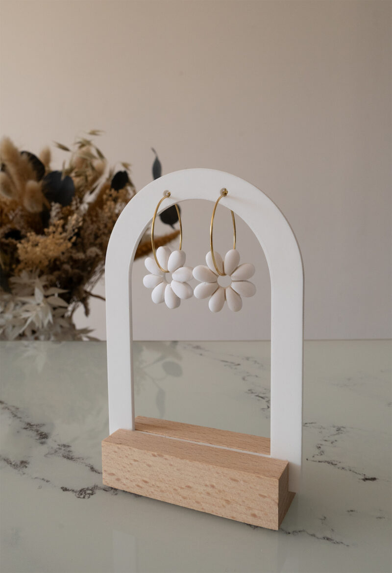 Apportez une touche de tendresse à votre tenue grâce aux créoles avec fleurs interchangeables, Marguerite. Ces boucles d’oreilles délicates se distinguent par une marguerite blanche posée sur une créole dorée ou argentée, à choisir selon vos préférences.