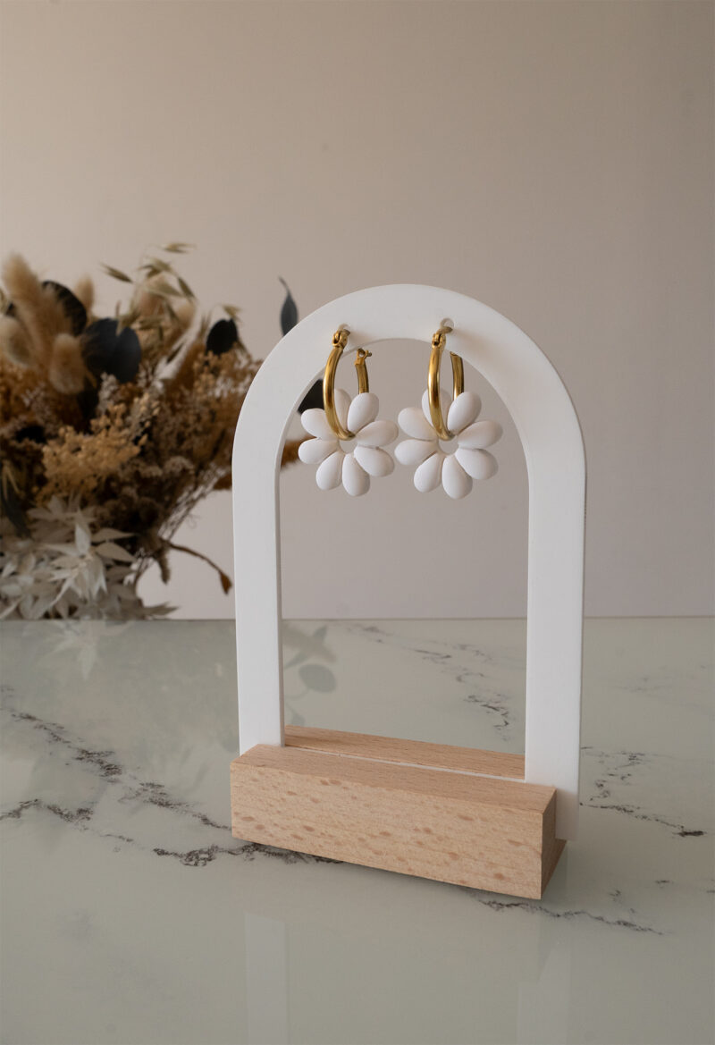 Apportez une touche de tendresse à votre tenue grâce aux créoles avec fleurs interchangeables, Marguerite. Ces boucles d’oreilles délicates se distinguent par une marguerite blanche posée sur une créole dorée ou argentée, à choisir selon vos préférences.