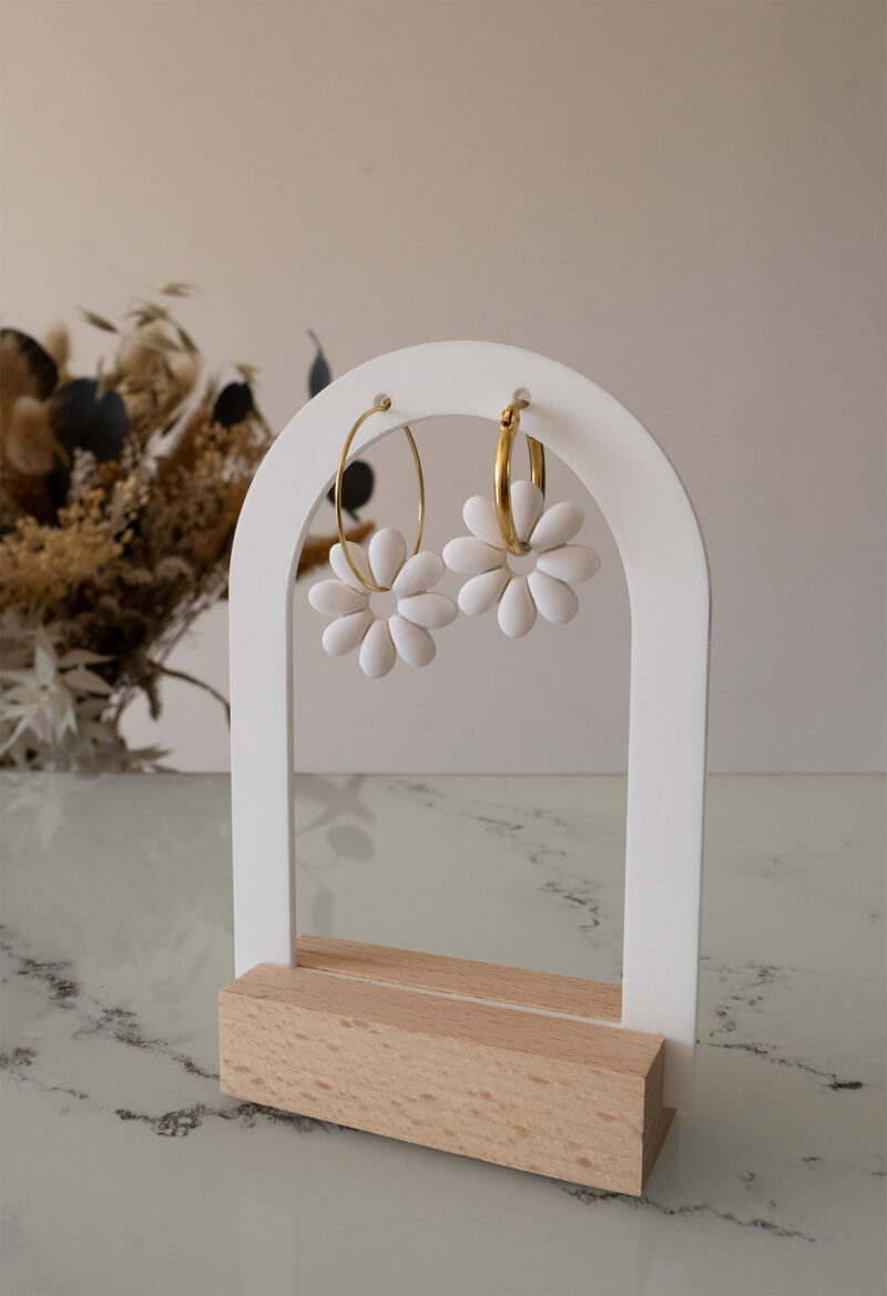 Apportez une touche de tendresse à votre tenue grâce aux créoles avec fleurs interchangeables, Marguerite. Ces boucles d’oreilles délicates se distinguent par une marguerite blanche posée sur une créole dorée ou argentée, à choisir selon vos préférences.