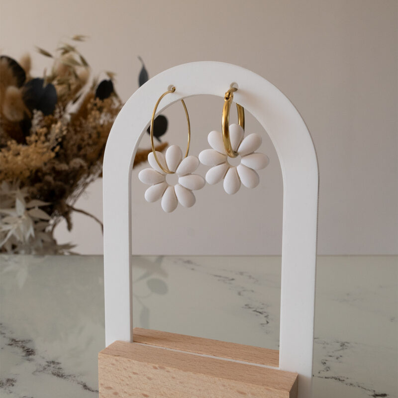 Apportez une touche de tendresse à votre tenue grâce aux créoles avec fleurs interchangeables, Marguerite. Ces boucles d’oreilles délicates se distinguent par une marguerite blanche posée sur une créole dorée ou argentée, à choisir selon vos préférences.