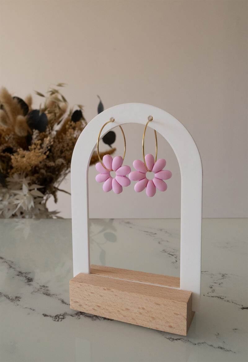 Apportez une touche de tendresse à votre tenue grâce aux créoles avec fleurs interchangeables, Marguerite. Ces boucles d’oreilles délicates se distinguent par une marguerite rose pale posée sur une créole dorée ou argentée, à choisir selon vos préférences.