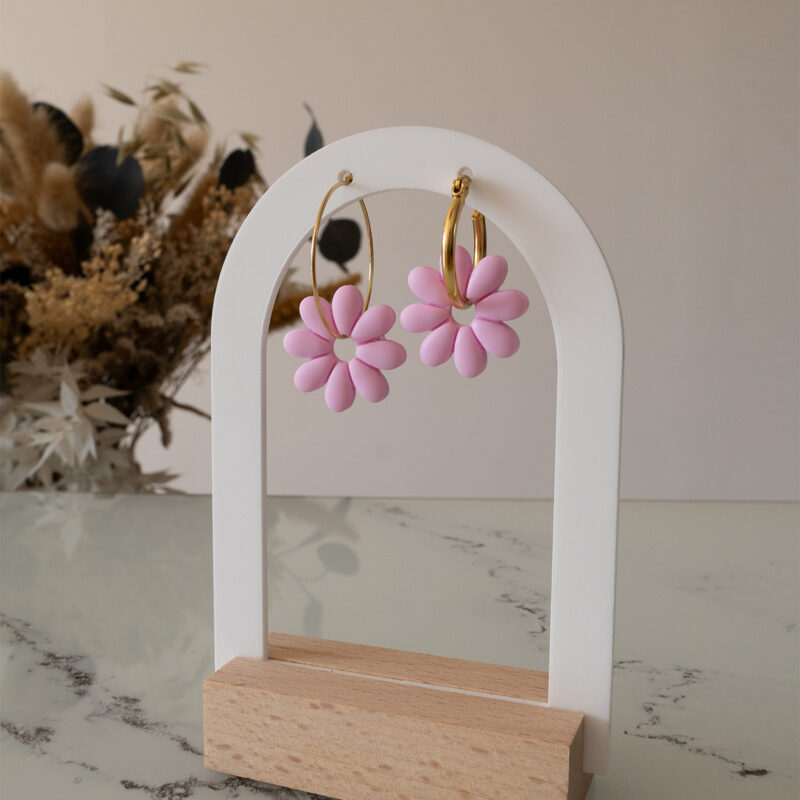 Apportez une touche de tendresse à votre tenue grâce aux créoles avec fleurs interchangeables, Marguerite. Ces boucles d’oreilles délicates se distinguent par une marguerite rose pale posée sur une créole dorée ou argentée, à choisir selon vos préférences.