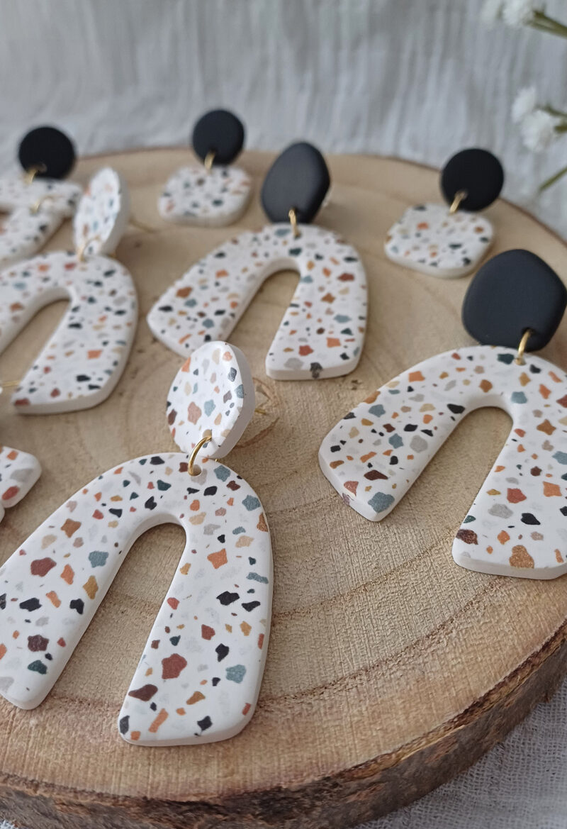 Des grosses boucles d'oreilles faites main avec arche, en terrazzo noir et marron. Des boucles d'oreilles pendantes, tendance à l'allure bohème. A s'offrir sur le site Un Bijou dans la Mare.