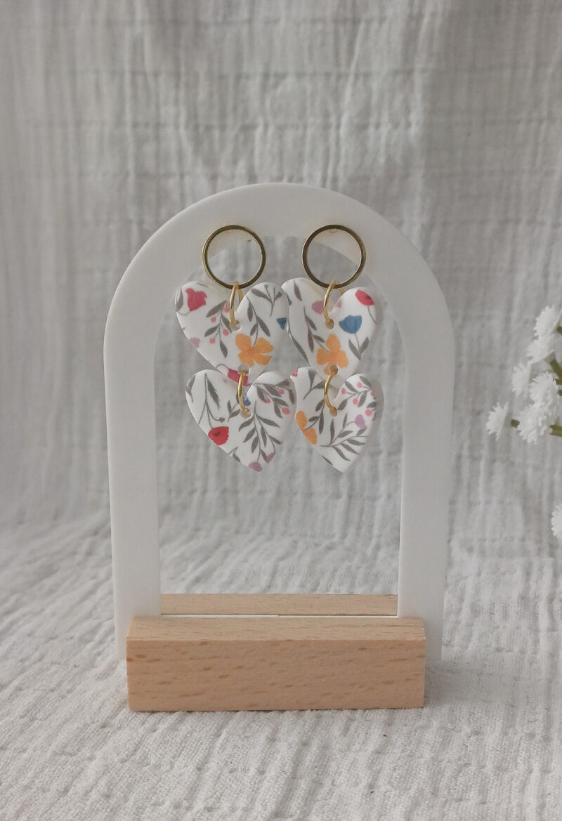 Les boucles d’oreilles pendantes Michelle incarnent une élégance romantique et intemporelle. Deux cœurs, des fleurs délicates et toute une histoire d’amour cachée dans un bijou... Voici les boucles d’oreilles Michelle qui rendent hommage à ma grand-mère et à son histoire d’amour avec mon grand-père. Ces boucles d’oreilles pendantes sont composées de trois parties : un cercle en acier inoxydable plaqué or 18k et deux cœurs en argile polymère aux motifs floraux rares et brevetés. Leurs couleurs douces ajoutent une touche de tendresse et de féminité à toutes vos tenues. Imposantes par leur taille mais incroyablement légères (3 grammes seulement), les boucles d’oreilles Michelle se portent, sans aucune gêne, tout au long de la journée.