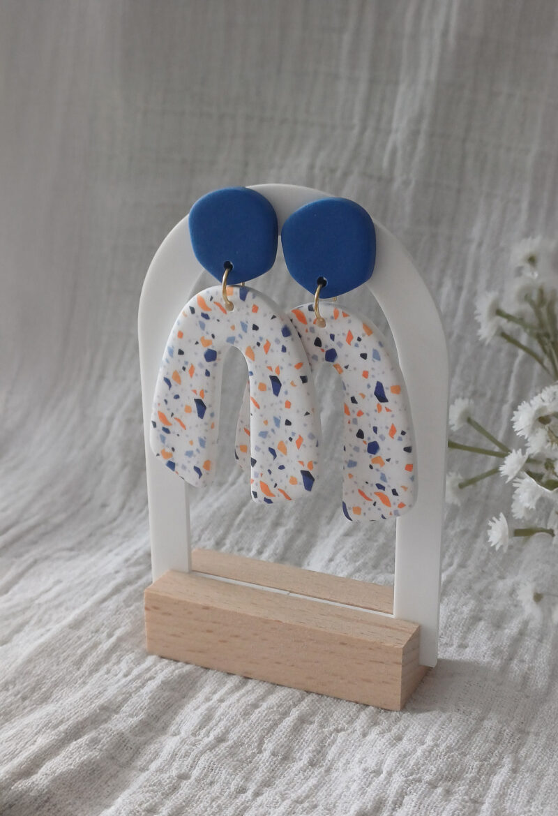 Des grosses boucles d'oreilles faites main avec arche, en terrazzo bleu et orange. Des boucles d'oreilles pendantes, tendance à l'allure bohème. A s'offrir sur le site Un Bijou dans la Mare.