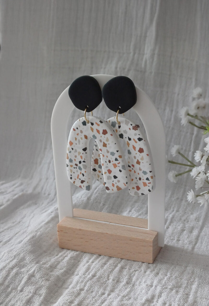 Des grosses boucles d'oreilles faites main avec arche, en terrazzo noir et marron. Des boucles d'oreilles pendantes, tendance à l'allure bohème. A s'offrir sur le site Un Bijou dans la Mare.