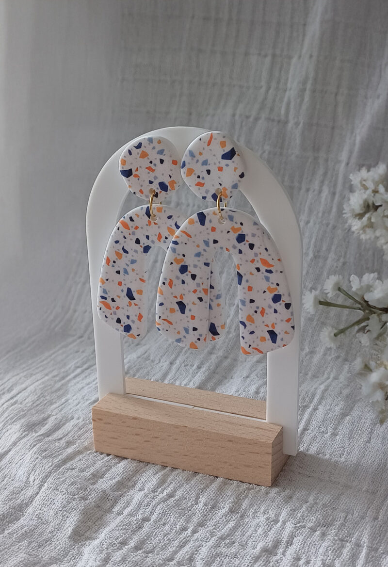 Des grosses boucles d'oreilles faites main avec arche, en terrazzo bleu et orange. Des boucles d'oreilles pendantes, tendance à l'allure bohème. A s'offrir sur le site Un Bijou dans la Mare.