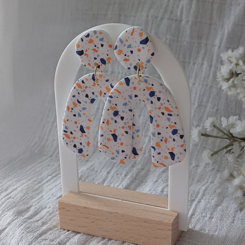 Des grosses boucles d'oreilles faites main avec arche, en terrazzo bleu et orange. Des boucles d'oreilles pendantes, tendance à l'allure bohème. A s'offrir sur le site Un Bijou dans la Mare.