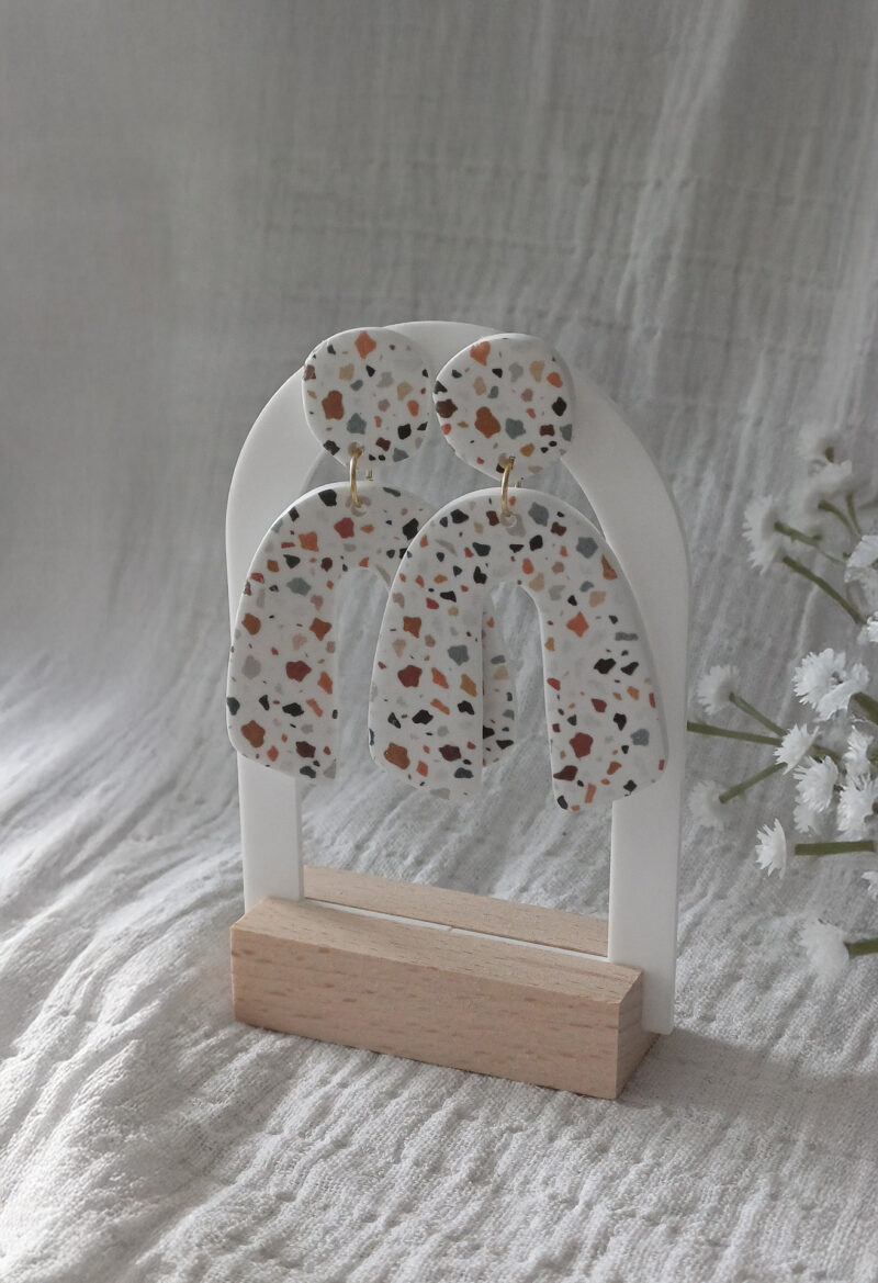 Des grosses boucles d'oreilles faites main avec arche, en terrazzo noir et marron. Des boucles d'oreilles pendantes, tendance à l'allure bohème. A s'offrir sur le site Un Bijou dans la Mare.