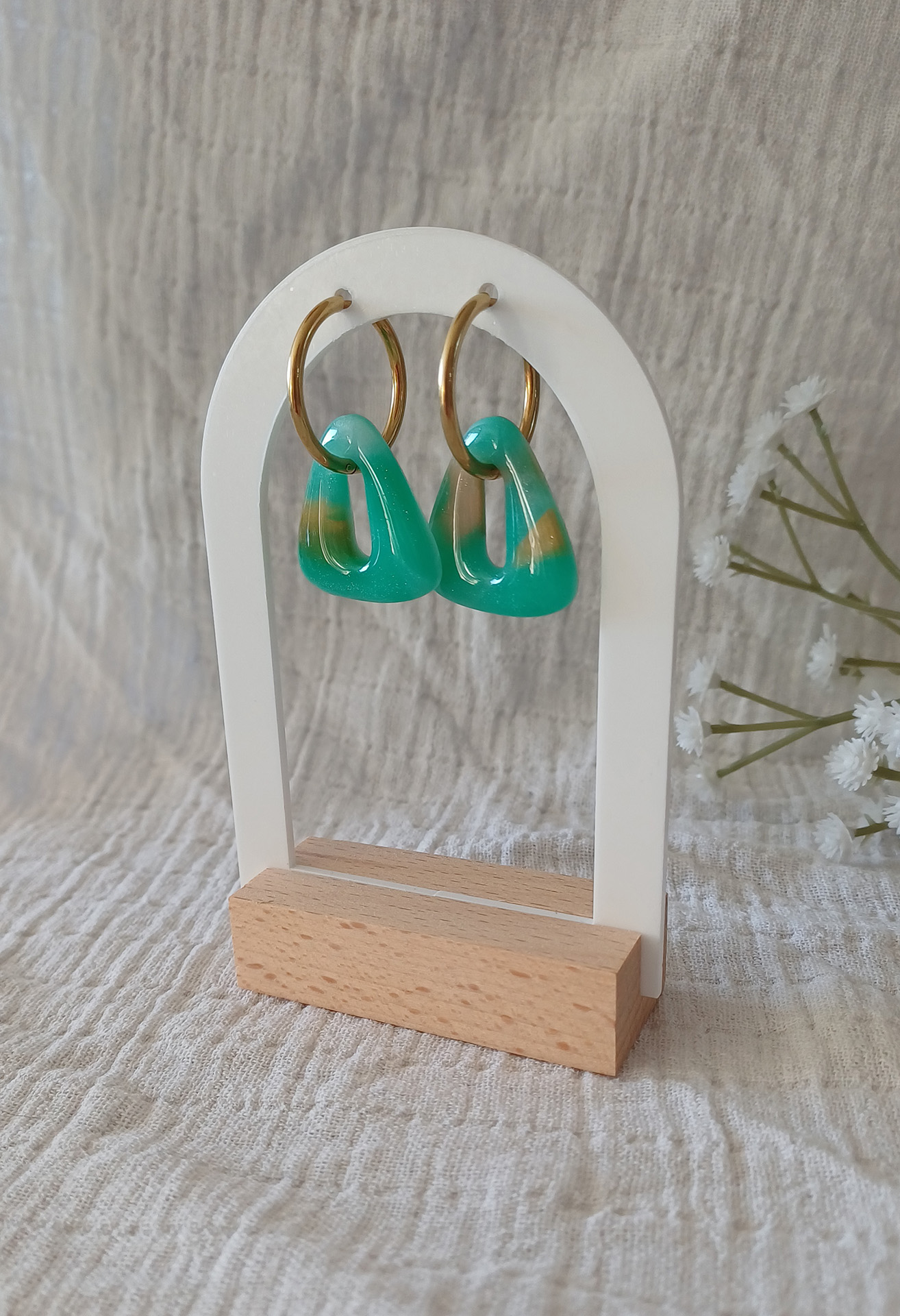 Façonnée à la main en argile polymère transparente, la pampille interchangeable Isis se métamorphose à la cuisson : les teintes vertes, blanches et dorées se fondent, se révèlent, et donnent vie à un effet pierre Amazonite unique à chaque paire. Cette paire de pampilles triangle s'adapte à toutes les tailles de créoles proposées en option.