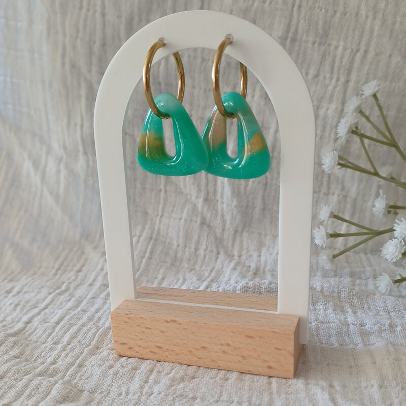 Façonnée à la main en argile polymère transparente, la pampille interchangeable Isis se métamorphose à la cuisson : les teintes vertes, blanches et dorées se fondent, se révèlent, et donnent vie à un effet pierre Amazonite unique à chaque paire. Cette paire de pampilles triangle s'adapte à toutes les tailles de créoles proposées en option.