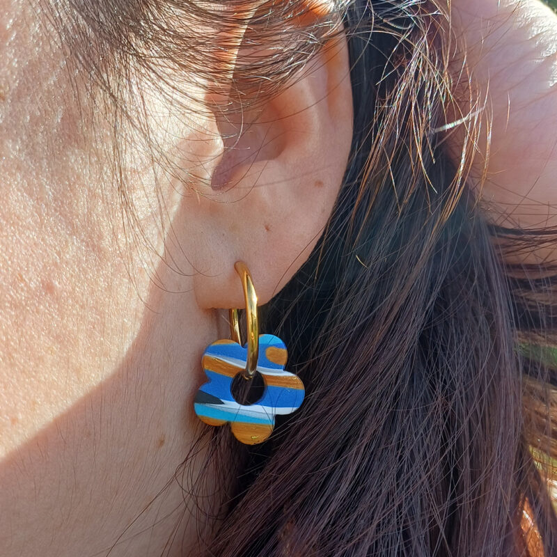 Apportez une touche poétique à vos looks avec les créoles avec fleurs interchangeables April. Ces boucles d’oreilles délicates se distinguent par une fine fleur à cinq pétales, marbrée, posée sur une créole à choisir selon vos préférences. Inspirées par la nature, polyvalentes et confortables, elles sublimeront aussi bien une tenue décontractée qu’un style plus sophistiqué.