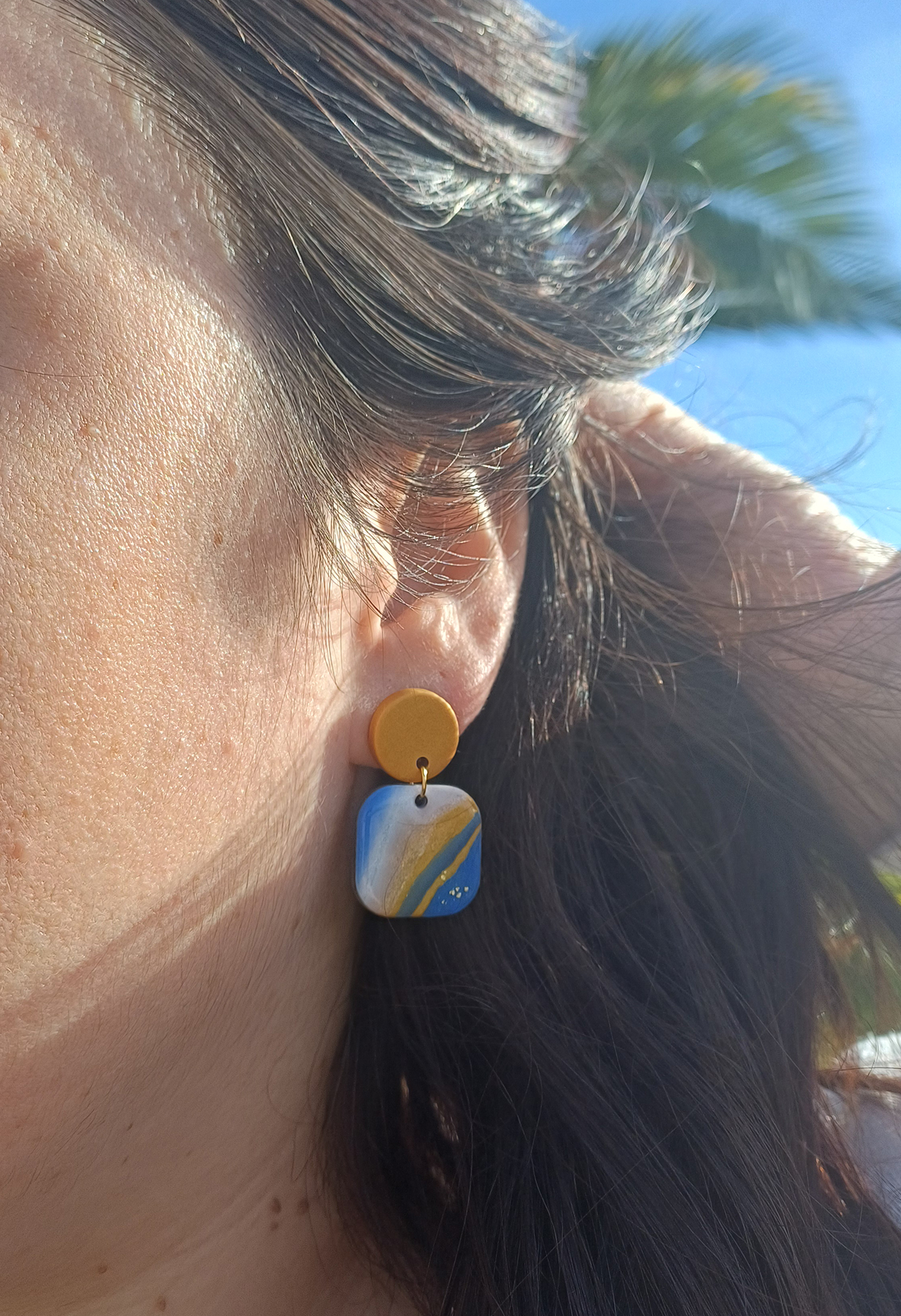 Ajoutez une touche de modernité minimaliste à votre style avec les boucles d’oreilles faites main Élodie. Ces pièces uniques associent un rond d’un beau doré nacré à un carré aux bords arrondis, marbré avec 3 couleurs de bleu différents, du blanc du noir et du doré nacré. Parfaites pour toutes les occasions, elles apportent une subtilité contemporaine à vos tenues, qu’elles soient casual ou habillées.